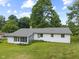 The rear exterior of the home is shown, with a screened in porch and a lush green lawn at 1841 Shady Ln, Martinsville, IN 46151