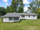 The rear exterior of the home is shown, with a screened in porch and a lush green lawn at 1841 Shady Ln, Martinsville, IN 46151