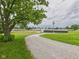 View of a gravel driveway leading to a neighborhood street with trees, offering ample parking at 203 Plum E St, Frankton, IN 46044