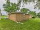 The back exterior of a brick home showing well-kept lawn and surrounding trees providing a tranquil setting at 203 Plum E St, Frankton, IN 46044