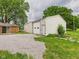 Metal garage with gravel driveway, next to a brick home, offering ample parking and storage at 203 Plum E St, Frankton, IN 46044