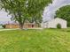 A metal storage building and brick home provide a tranquil view with a well maintained grass and gravel area at 203 Plum E St, Frankton, IN 46044