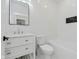 Elegant white bathroom with modern fixtures, sleek mirror, and tiled walls at 2125 N Pasadena St, Indianapolis, IN 46219