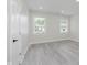Bright bedroom with stylish gray flooring, multiple light-filled windows, and neutral decor at 2125 N Pasadena St, Indianapolis, IN 46219
