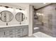 Beautiful bathroom featuring a double sink vanity, modern fixtures, round mirrors, and a glass enclosed shower with tile surround at 214 Handley St, Indianapolis, IN 46222