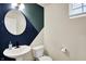 Stylish half bathroom with a unique geometric accent wall, round mirror, modern sink, and a window for natural light at 214 Handley St, Indianapolis, IN 46222