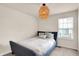 Cozy bedroom with neutral walls, carpet floors, a blue bed frame, and a window for natural light and ventilation at 214 Handley St, Indianapolis, IN 46222