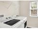 Bright laundry room featuring a modern washer and dryer, window with natural light, and a convenient overhead shelf at 214 Handley St, Indianapolis, IN 46222