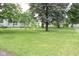 Lush green backyard with mature trees, providing a private and serene outdoor space at 220 S 2Nd St, Summitville, IN 46070
