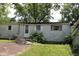 View of the back exterior of the home showing back door and overgrowth at 220 S 2Nd St, Summitville, IN 46070