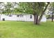 Exterior of a home featuring a well-maintained lawn, siding, and a shade tree at 220 S 2Nd St, Summitville, IN 46070