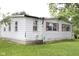 View of the side exterior highlighting its foundation, windows, and siding, surrounded by greenery at 220 S 2Nd St, Summitville, IN 46070