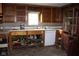 Outdated kitchen featuring cabinetry, a window, and a white appliance at 220 S 2Nd St, Summitville, IN 46070