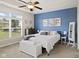 Comfortable bedroom featuring a blue accent wall, large window, and ceiling fan at 2246 Heather Glen Way, Franklin, IN 46131