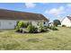 Landscaped backyard featuring a stone-enclosed patio and a well-maintained lawn at 2308 E Mill Stream Dr, Greenfield, IN 46140