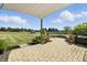 Paver patio with overhead sun sail, lush landscaping, and a beautiful backyard view at 2308 E Mill Stream Dr, Greenfield, IN 46140