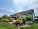 Charming backyard showcasing a lovely flower garden, deck, and comfortable seating area with fire pit at 2308 E Mill Stream Dr, Greenfield, IN 46140