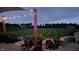 Backyard patio at dusk featuring lighting, string lights, and manicured lawn at 2308 E Mill Stream Dr, Greenfield, IN 46140