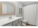 Neutral bathroom features a single vanity, framed mirror, shelving, toilet, and shower with a curtain at 2308 E Mill Stream Dr, Greenfield, IN 46140