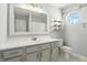 Bright bathroom with gray vanity, stylish mirror and an octagonal window letting in natural light at 2308 E Mill Stream Dr, Greenfield, IN 46140