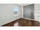 Bright bedroom with hardwood floors, a large window, and an accent wall with built-in shelves at 2308 E Mill Stream Dr, Greenfield, IN 46140