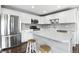 Bright kitchen features white cabinets, stainless steel appliances, gray backsplash, and kitchen island with breakfast bar seating at 2308 E Mill Stream Dr, Greenfield, IN 46140