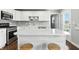 Well-lit kitchen showcasing white cabinets, stainless steel appliances, and a center island with barstool seating, creating a modern design at 2308 E Mill Stream Dr, Greenfield, IN 46140