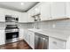 Updated kitchen features stainless appliances, gray backsplash, white cabinets, modern countertops, and built in plant shelves at 2308 E Mill Stream Dr, Greenfield, IN 46140
