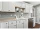 Updated kitchen features stainless steel appliances, gray backsplash, white cabinets, and modern countertops at 2308 E Mill Stream Dr, Greenfield, IN 46140