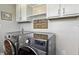 Modern laundry room with gray front load machines, white cabinets, and a cute 'lost socks' sign at 2308 E Mill Stream Dr, Greenfield, IN 46140