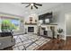 Comfortable living room featuring a cozy fireplace, large windows, and hardwood floors, perfect for relaxation and entertainment at 2308 E Mill Stream Dr, Greenfield, IN 46140
