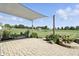 Covered outdoor patio area with greenery, pavers, and lovely landscaping at 2308 E Mill Stream Dr, Greenfield, IN 46140