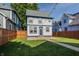 Well-kept backyard featuring a green lawn, tall wooden fence, with string lights for evening enjoyment at 2347 N Pennsylvania St, Indianapolis, IN 46205