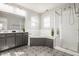 Spacious bathroom featuring a double vanity, large tub, and a glass enclosed shower for a luxurious experience at 2347 N Pennsylvania St, Indianapolis, IN 46205