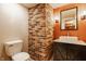 Bathroom with a modern sink, decorative mirror, and unique brick accent wall at 2347 N Pennsylvania St, Indianapolis, IN 46205
