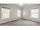 A well-lit bedroom with three large windows, neutral paint, and plush carpeting at 2347 N Pennsylvania St, Indianapolis, IN 46205