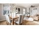 Open-concept dining area with a wooden table, upholstered chairs, stylish lighting, and a view into the living room at 2347 N Pennsylvania St, Indianapolis, IN 46205