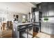 Bright open kitchen with granite countertops, gray cabinets, stainless steel refrigerator, and adjacent dining area at 2347 N Pennsylvania St, Indianapolis, IN 46205