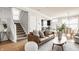 Cozy living room with a comfortable brown leather sofa, a modern rug, and access to the staircase and kitchen at 2347 N Pennsylvania St, Indianapolis, IN 46205