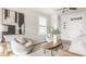 Bright living room with plush seating, modern artwork, and ample natural light from the large window at 2347 N Pennsylvania St, Indianapolis, IN 46205
