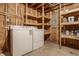Unfinished basement laundry area with a washer, dryer, and shelving for storage at 2347 N Pennsylvania St, Indianapolis, IN 46205