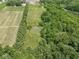 Aerial view of wooded land and property featuring a tranquil pond surrounded by lush greenery at 2868 S 525 W, Trafalgar, IN 46181