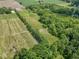 Aerial view of wooded land and property featuring a tranquil pond surrounded by lush greenery at 2868 S 525 W, Trafalgar, IN 46181