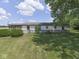 Wide shot of the back of the home showing the lawn, lawn mower and landscaping at 2868 S 525 W, Trafalgar, IN 46181