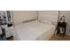 Cozy bedroom featuring a bed with a white tufted headboard and small black bedside table at 291 Lakemoore St, Brownsburg, IN 46112