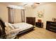 Comfortable bedroom boasts wood floors, ceiling fan, complemented by neutral curtains and a dresser at 291 Lakemoore St, Brownsburg, IN 46112