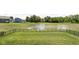 Expansive backyard with well-kept lawn, black fence, and pond access, perfect for outdoor activities at 3969 Canning St, Danville, IN 46122
