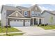 Charming two-story home with a brick and siding facade, featuring a spacious three-car garage and manicured lawn at 3969 Canning St, Danville, IN 46122