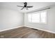 Bright bedroom featuring hardwood floors, a ceiling fan, and a large window for natural light at 413 E Caven St, Indianapolis, IN 46225