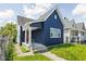 Charming blue home, featuring a quaint porch, and a pop of color with the bright orange front door at 413 E Caven St, Indianapolis, IN 46225